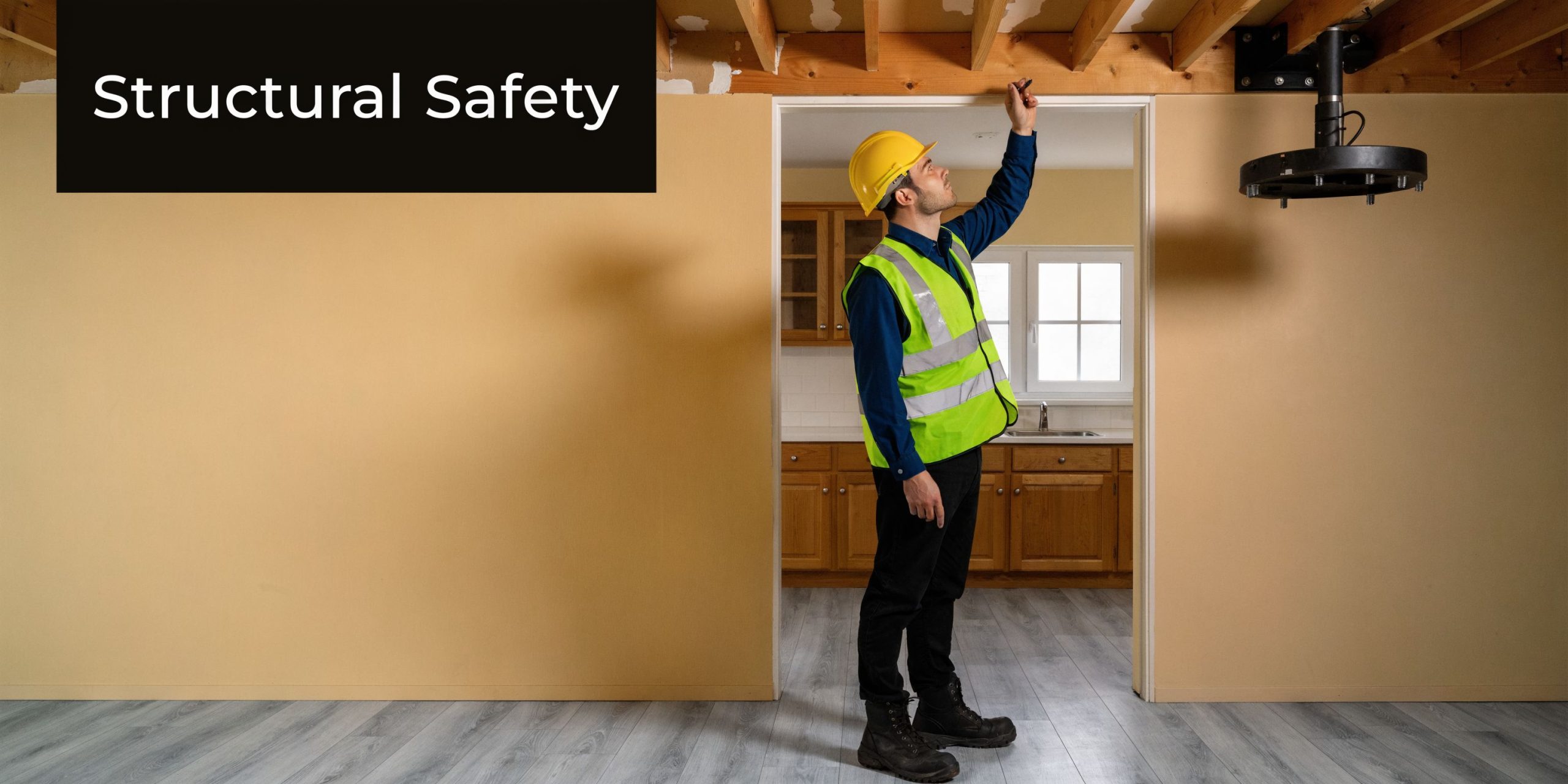 A professional construction inspector examining structural ceiling beams in a home renovation project.