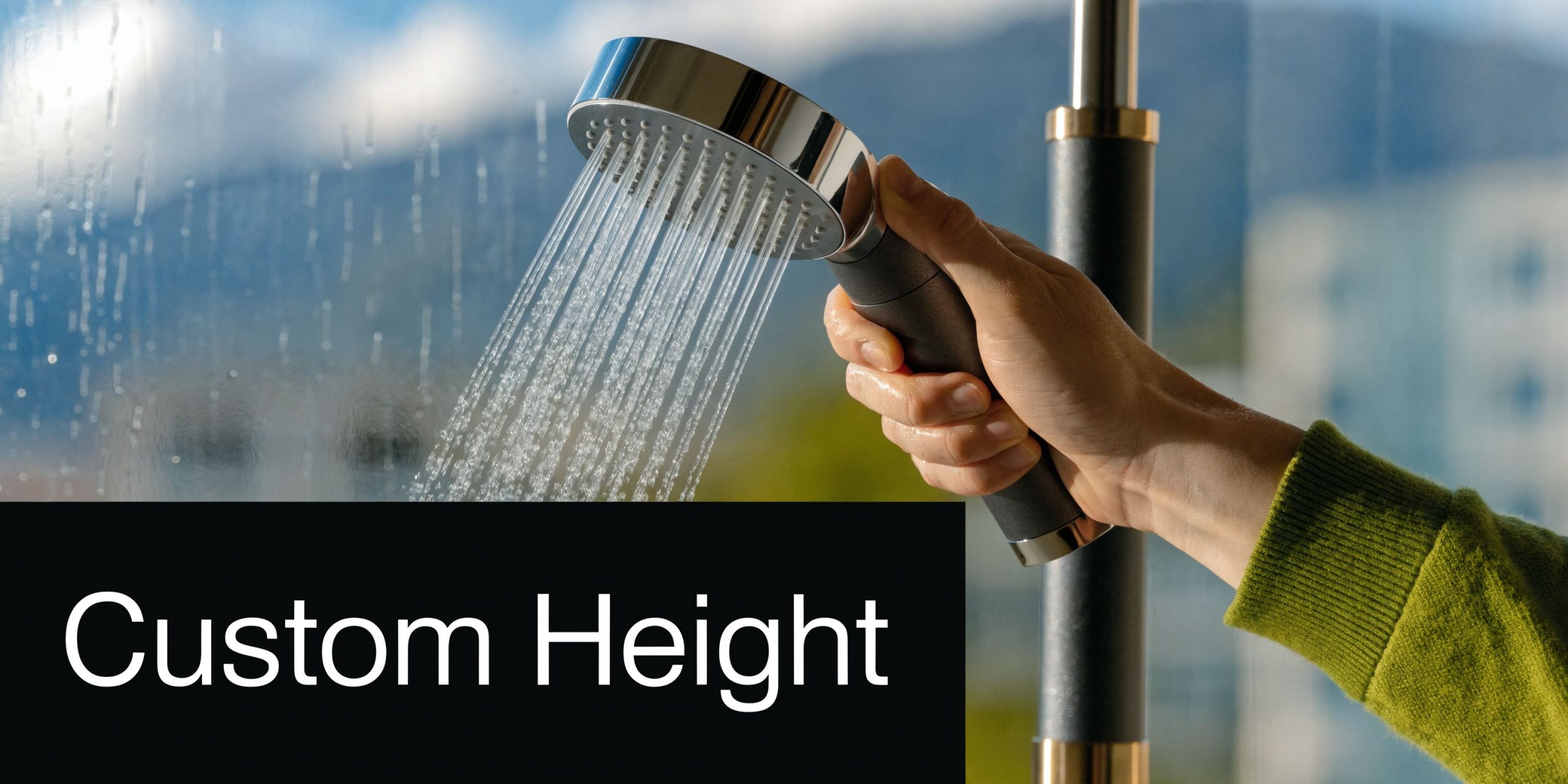 A hand holding a modern shower head with adjustable height settings in a bright indoor setting